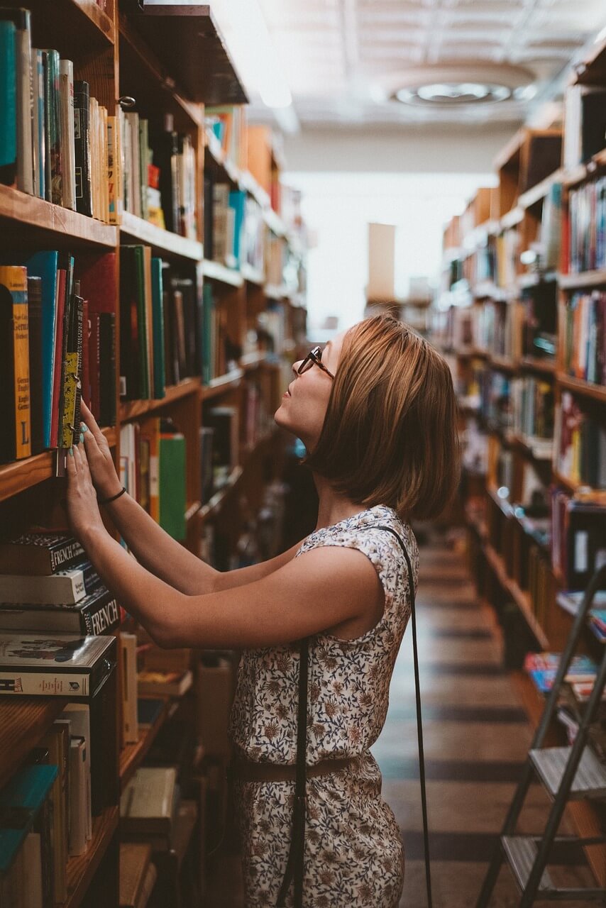 Woman choosing a book in a library